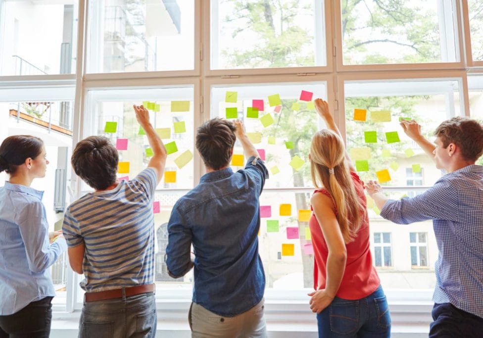 Junge Studenten im Seminar für Brainstorming mit bunten Zetteln