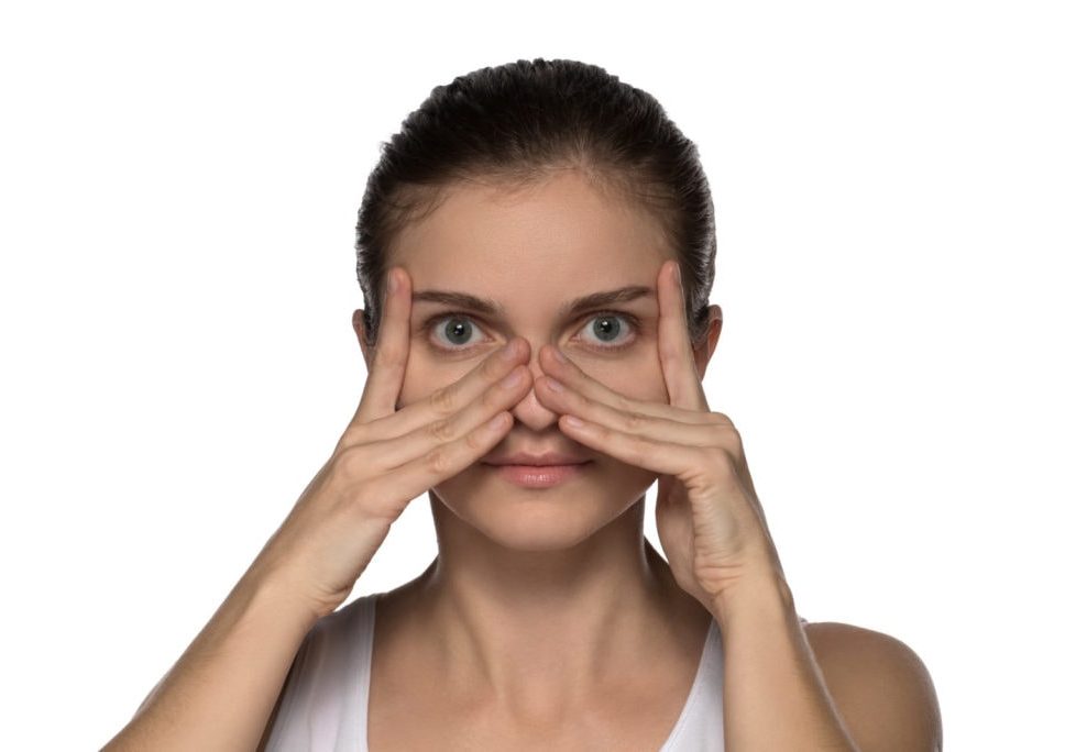 Massage, yoga, gymnastics or rejuvenating exercises for the muscle of the face makes the girl own hands on a white background