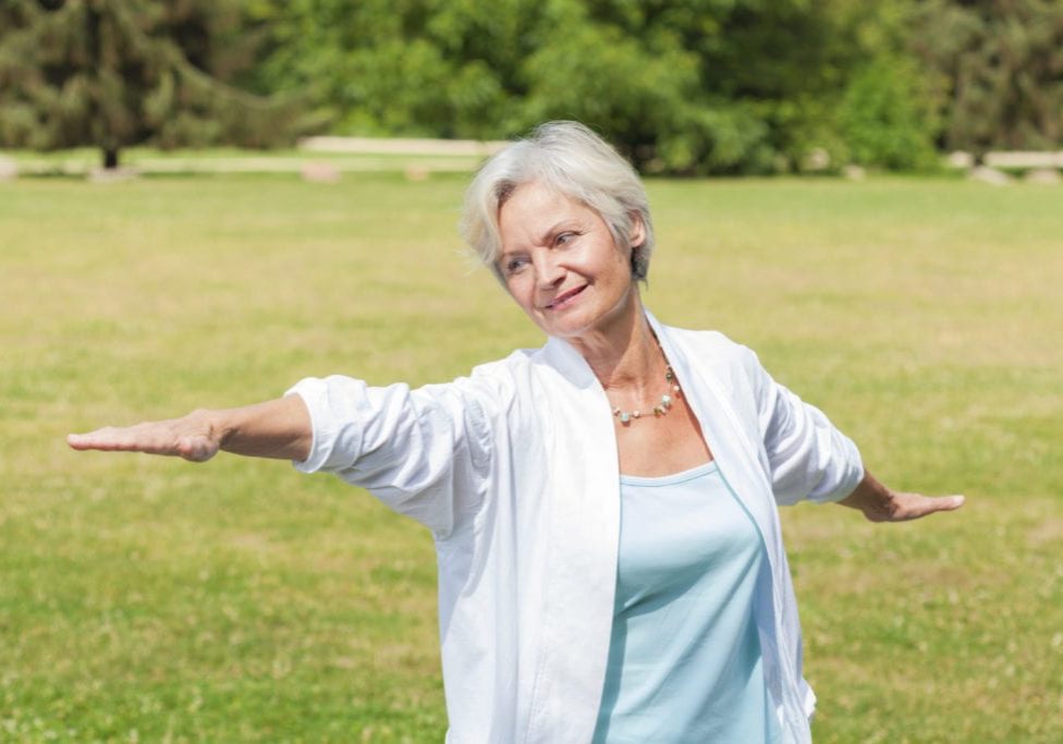 best ager women practising yoga and tai chi outdoors