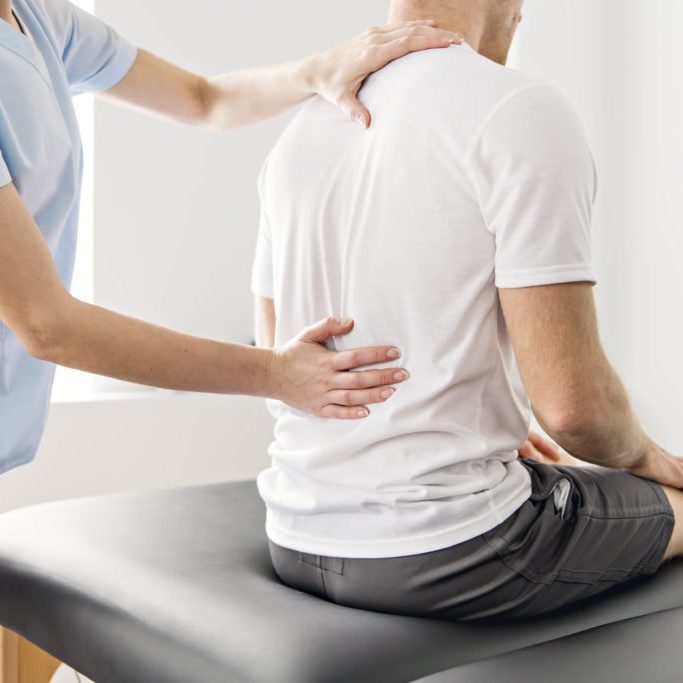 Patient at the physiotherapy doing physical exercises with his therapist Physiotherapy Session with a Physiotherapist