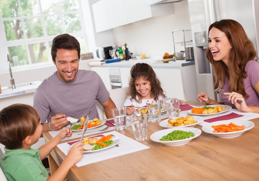 Family laughing around a good meal in kitchen