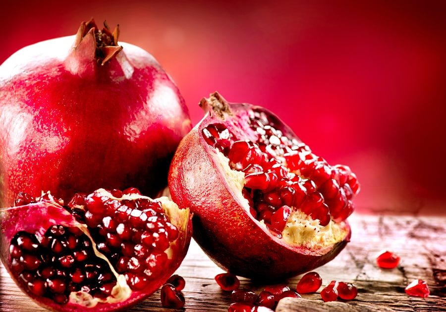 Pomegranate fruit. Pomegranates over Red Background. Organic Bio fruits