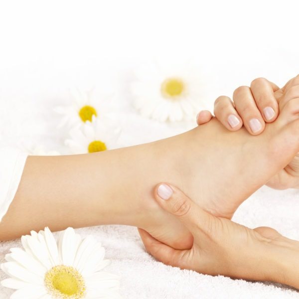 Female hands giving massage to soft bare foot